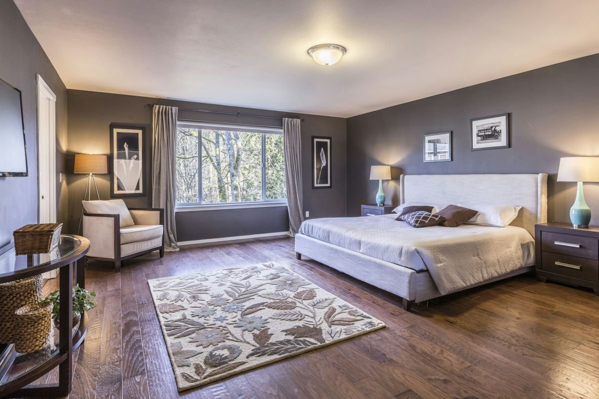 Bedroom with warm grey painted walls and a large window