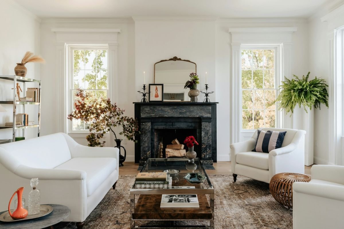 Period living room with a black fireplace, tall sash windows and freshly painted white walls