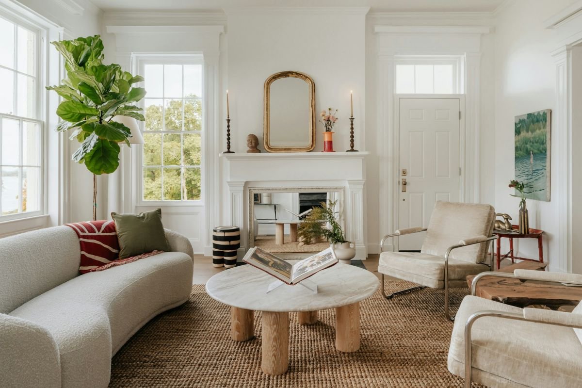 Bright living room with a white painted fireplace, gilt mirror and soft neutral walls